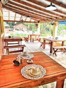 a patio with picnic tables and hats on a wooden table at Pousada Sabiá in Brotas