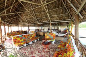 Zanzibar Bay Resort & Spa في اوروا: غرفة بها كراسي وأرجوحة في منتجع