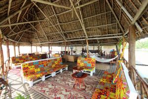 a room with chairs and a hammock in a resort at Zanzibar Bay Resort & Spa in Uroa