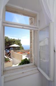 una ventana abierta con vistas al océano en Rooms&Studios Rina, en Dubrovnik