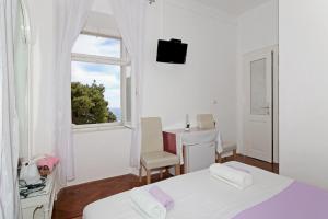 Habitación blanca con cama y ventana en Rooms&Studios Rina, en Dubrovnik