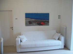 un sofá blanco en una habitación con una pintura en la pared en Massone Climbing Home, en Arco