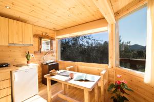 eine Küche in einem Blockhaus mit einem Tisch und einem Fenster in der Unterkunft Romantic Tree House in Kato Pavliana