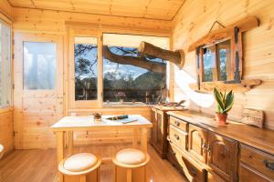 eine Küche in einem Blockhaus mit einem Tisch und Stühlen in der Unterkunft Romantic Tree House in Kato Pavliana