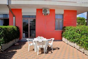 a table and chairs in front of a house at Condominio Biloba-Gemini in Bibione