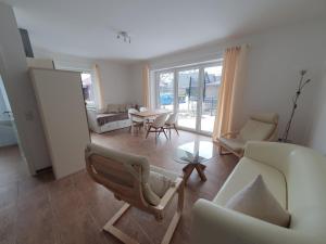a living room with a couch and chairs and a table at Haus Taybeerweg in Aurich
