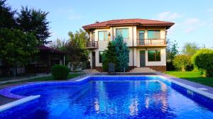 a house with a swimming pool in front of a house at Вила Силва - Villa Silva in Bŭlgarevo