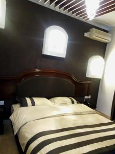 a bedroom with a bed with a black wall at Emerald Hotel Kampala in Kampala