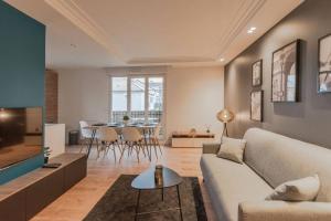 una sala de estar con un sofá y una mesa en Arty Paris apartment Disneyland, en Magny-le-Hongre