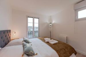 Un dormitorio con una cama grande con dos toallas encima. en Arty Paris apartment Disneyland, en Magny-le-Hongre