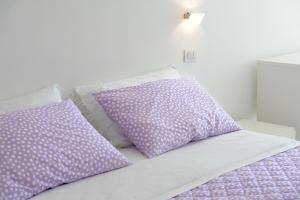 a bed with purple pillows on top of it at Il Barilotto in Positano