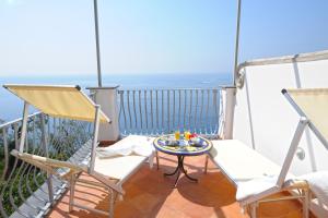 a balcony with chairs and a table and the ocean at Il Barilotto in Positano