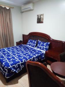 a bedroom with a bed and a table and a couch at Emerald Hotel Kampala in Kampala