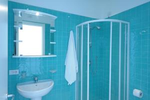 a blue tiled bathroom with a sink and a shower at Il Barilotto in Positano