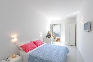 a bedroom with a bed with pink and blue pillows at Il Barilotto in Positano
