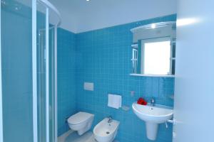a blue bathroom with a toilet and a sink at Al Barilotto del Nonno in Positano