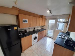 a kitchen with a black refrigerator and a dishwasher at Kingswood House in Nottingham