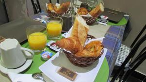 stół z dwoma koszami wypieków i dwoma kieliszkami soku pomarańczowego w obiekcie Hôtel de Choisy w Paryżu