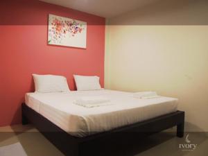 a bed in a room with a red wall at Ivory Phi Phi Island in Phi Phi Don