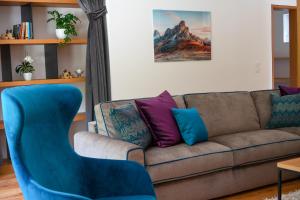 a living room with a couch and a blue chair at Chalet Tolder in San Candido