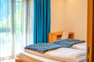 a room with a chair and a window with blue curtains at Chalet Tolder in San Candido +28 photos