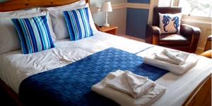 1 dormitorio con 1 cama con toallas en The Top House Inn en Lizard