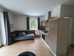 a kitchen with a couch in the middle of a room at Haus Taybeerweg in Aurich