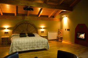 a bedroom with a large bed and a fireplace at Casas la Ribera Ordesa in Escalona