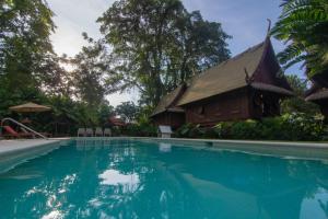 a resort with a swimming pool and a building at Lanna Ban Hotel in Puerto Viejo
