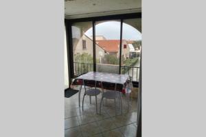 a table and chairs on the balcony of a house at Studio mezzanine en résidence avec piscine au village in Le Barcarès +6 photos