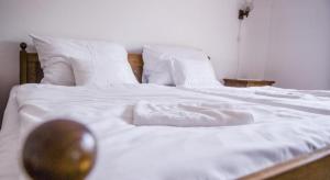 1 cama blanca grande con sábanas y almohadas blancas en Zseri Vadászház, en Fehérvárcsurgó