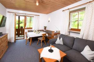 ein Wohnzimmer mit einer Couch und einem Tisch in der Unterkunft Leiterhof inkl. Chiemgaukarte in Ruhpolding