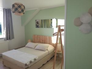 Dormitorio pequeño con cama y escalera en Lucriolla, en Champtoceaux