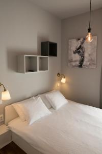 a bedroom with a white bed with two lights on it at S&L3 REPUBLIC ZAGREB CENTER in Zagreb