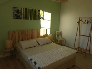 a bedroom with a bed in a room with green walls at Lucriolla in Champtoceaux