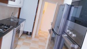 een keuken met een roestvrijstalen koelkast en een wastafel bij TOPO Apartment in Ponta Delgada