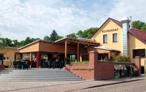 a restaurant with tables and chairs in front of a building at Zum Alten Hafen in Rathenow