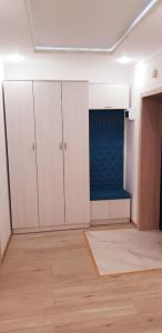 een lege kamer met witte kasten en een blauwe muur bij Аблайхана 1/3 in Köksetaw