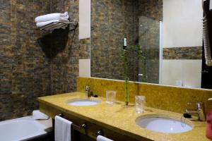 a bathroom with two sinks and a large mirror at Hotel Albaida Nature in Mazagón