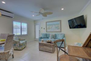 a living room with a blue couch and a tv at LuLu's Key House Green 1/1 Upstairs in Siesta Key