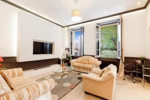 uma sala de estar com duas cadeiras e uma televisão em Villa Maiffret 1 YourHostHelper em Cannes