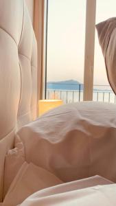 a white bed with a view of the ocean at Naro Suites and Rooms in Bacoli