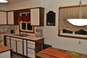 cocina con fregadero, mesa y ventana en Arhaus 2, en Grand Forks