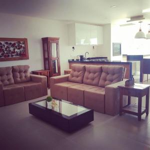 a living room with a couch and a coffee table at Apto. 3 dorm. entre Praia da Cal e Lagoa Violão in Torres