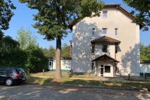 a car parked in front of a large white building at FeWo "Belvedere" in Dallgow-Döberitz vor den Toren Berlins in Dallgow