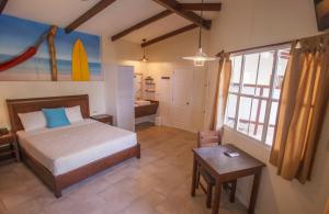 a bedroom with a bed and a table and a room at Hotel Roca Sunzal in La Libertad