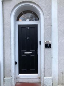 a black door in a building with an arched window at Mariyka House in Torquay