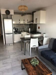 Il dispose d'une cuisine et d'un salon avec un canapé et une table. dans l'établissement Appartement Vue Mer - Sète, à Sète