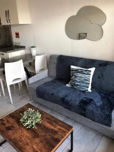 - un salon avec un canapé bleu et une table dans l'établissement Appartement Vue Mer - Sète, à Sète