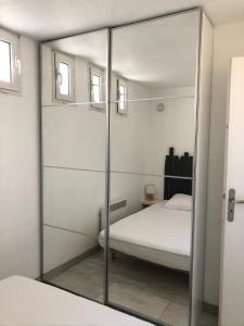 - un miroir dans une chambre avec un lit et un lit dans l'établissement Appartement Vue Mer - Sète, à Sète